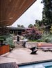 Once unkempt terrain (1), the lot was replanted by Elysian Landscapes. Board-formed concrete walls now hold a lush collection of Bloodgood Japanese maple trees, Canyon Prince wild rye grasses, and Blue Fox Tail agaves. A Spun stool by Heatherwick Studio for Magis joins an outdoor furniture set by Plain Air. Photo 5 of Modernist Gem Revival modern home
