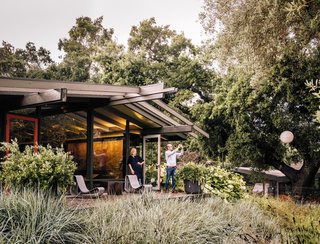 Fields of native grasses connect the main residence, situated at the top of the slope, to the new structures scattered below. 