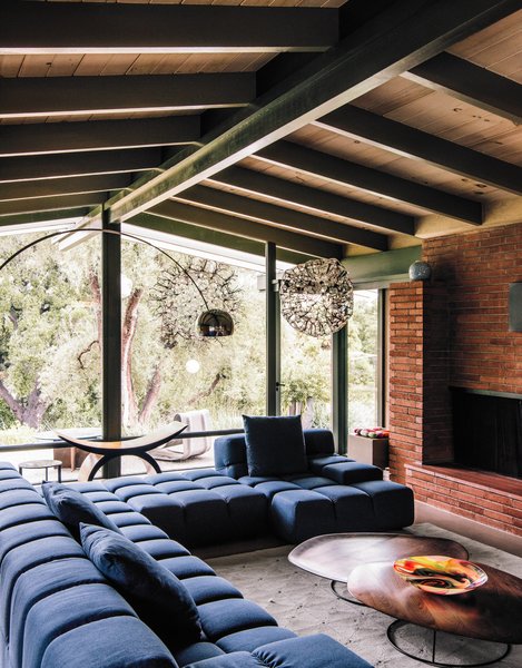 The architects maintained the midcentury post-and-beam construction and Japanese-inspired details of the original building, while brightening and expanding the interior living spaces. Patricia Urquiola’s Tufty-Time sofa for B&B Italia meets Pebble coffee tables by Nathan Yong for Ligne Roset in the living room. Photo 12 of Modernist Gem Revival modern home
