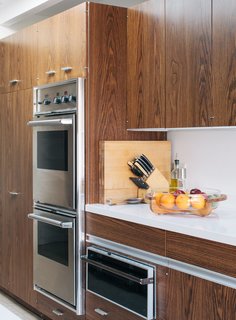 In the kitchen, the couple added a skylight and replaced blue Formica counters with white quartz, but they kept the cabinetry installed in the 1980s and a vintage Thermador bread warmer.