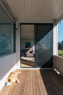 Roscoe, the couple’s English bulldog, enjoys the sun on the covered deck that connects the living room to a bedroom that was added before they arrived. It’s now occupied by the Lemkins’ daughter, Lucille.