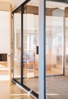 Tyler relaxes in the living room, which is visible through windows from both the rear patio and the master bedroom. "At night when we’re entertaining outside, the house lights up like a jewel box," he says. 