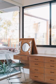 Situated in a built-in cabinet, a folding vanity in the master bedroom remains as it was when the home was built. "We knew that with some work, the house could be brought back to a clean and simple classic modern home," Tyler says.