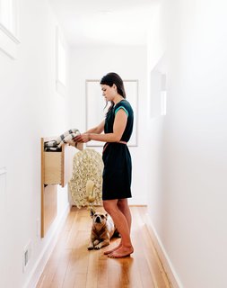 Sarah accesses a custom storage unit in the hallway, an addition that made use of a space behind the wall. 