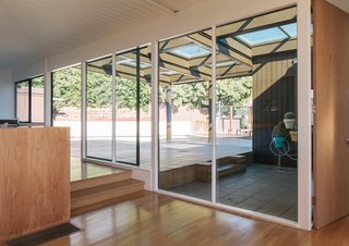Only a partial covering remains over the patio off the living and dining rooms. "It’s amazing how light and airy the house is now compared to how drab and dark it felt when we first moved in," says Tyler, an art advisor. The three-ring planter is by Eric Trine.