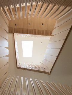 What’s the Twist Behind This Home’s Sinuous Staircase? Ordinary Plywood - Photo 2 of 14 - Here, the material palette continues: Plywood makes up the deep window frames, built-in shelving, and wall panels, which have been cut into gently jagged, unconventional forms.