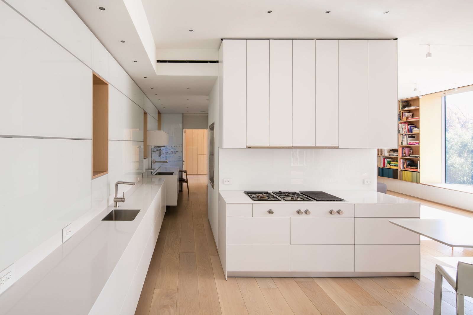 A cooktop and refrigerator from Gaggenau, Bulthaup cabinets, a Miele oven, and an Asko dishwasher outfit the all-white kitchen, which is located onthe entry-level floor.