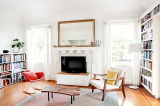 Check Back - Photo 7 of 14 - The adjoining living room, formerly the dining area, is kept free of playthings, focusing attention on an Eames rocker, a rug by Peace Industry, and a live-edge coffee table by Cheng+Snyder. 