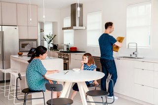 Check Back - Photo 9 of 14 - When the residents couldn’t find a suitable four-person cafe table for the kitchen, Snyder made one from Baltic birch plywood and Formica for $500. It is surrounded by chairs by Afteroom for Menu. NUD pendants hang overhead. 