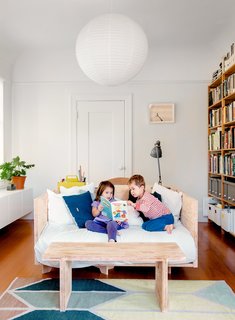 Check Back - Photo 12 of 14 - A pendant hangs above a custom sofa/bed and matching coffee table by Cheng+Snyder.