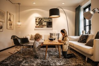 Urban Renewal - Photo 4 of 7 - She replaced the existing windows with custom JVK Vinduer designs, but could not alter the shape or size of the apertures. A VP Globe lamp by Verner Panton hangs from a corner of the living room, illuminating an RAR rocker by Charles and Ray Eames for Vitra.