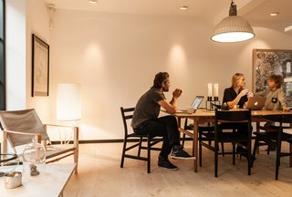 Urban Renewal - Photo 5 of 7 - "The house really works well because we don’t have to sit in each other’s laps," Mia says. A CH327 dining table and CH47 chairs by Hans Wegner for Carl Hansen & Søn provide a gathering place on the first floor, lit by a vintage pendant and Gubi’s Pedrera PD2 floor lamp.