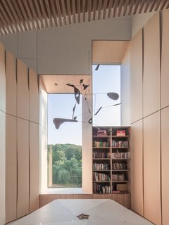 House of the Week: Plywood Perfection - Photo 1 of 2 - In renovating a historic brick home for family friends in Washington, D.C., architect Nader Tehrani of NADAAA used ordinary plywood to reconceive the central staircase. Lined with a series of striated, geometric panels, the resulting structure is lit by a polygonal skylight above. Tehrani also designed the Pentavola table—featuring five sides, one for each member of the family—which they use as a communal workspace on the second-floor landing.