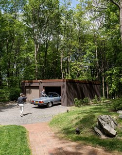 For the garage, the couple replaced rotted timbers, swapped in new gutters, and stained the exterior Cordovan Brown by Benjamin Moore to match the home and pool house. 