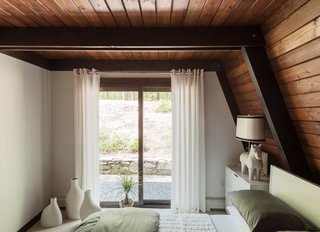 The guest bedrooms feature lighting by Jonathan Adler, including a Horse table lamp in the downstairs unit and an Antwerp pendant upstairs. 