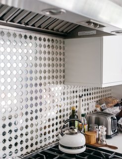 The pendants over the kitchen island are from Cisco Home; the bar chairs are by Studio One for Lost & Found. The patterned concrete tile floor is from Mission Tile West, as is the mirrored backsplash, which was originally meant for the living room fireplace. "I think we over-ordered," Lena recalls. "So I said, ‘Let’s do a disco backsplash.’ It just needs to make you smile, and I think it does."