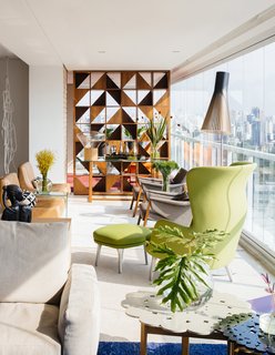 Overlooking a Niemeyer Masterpiece, This Flat is Filled with Brazilian Modern Gems - Photo 3 of 9 - FCstudio updated the 5,000-square-foot apartment by removing several walls in central areas to clarify views and simplify the overall floor plan. The firm also custom-designed the Brazilian walnut room divider with a striking geometric pattern that allows light to traverse throughout the living area. 