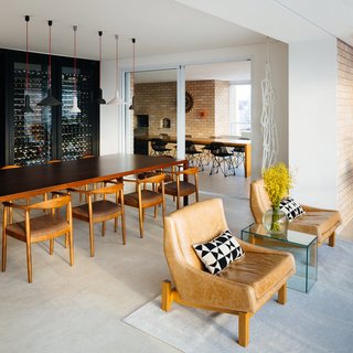 Overlooking a Niemeyer Masterpiece, This Flat is Filled with Brazilian Modern Gems - Photo 6 of 9 - In the dining area, a custom wine rack doubles as a partition for the open plan. The adjacent door leads to an expansive enclosed terrace.