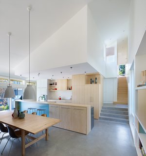 A Suburban Vancouver Home Edits its Privacy Settings - Photo 4 of 5 - The homeowners requested that color be integrated throughout the house; a wall underneath the countercovered in Benjamin Moore’s Covington Blue is one bright detail. Caravaggio pendants by Cecilie Manz for Lightyears hang above an IKEA tableand Eames chairs. 
