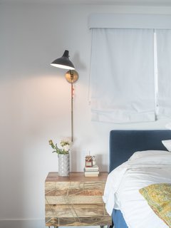 A downstairs guest bedroom is a welcome retreat for visitors. "Because I do so much traveling, if someone comes to stay, I want them to feel they can just be," says Lena. The Roar + Rabbit brass-inlaid nightstand is from West Elm. 