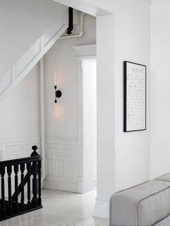 After restoring and renovating the interior of their four-story brownstone in Brooklyn’s Bedford-Stuyvesant neighborhood, Jeff Madalena and Jason Gnewikow—creative entrepreneurs and self-described interiors obsessives—outfitted the historic 1910 space with a minimal black-and-white palette, down to the stair railing and original moulding and wainscoting. Sparse, modern pieces—like a two-pronged sconce they designed for the parlor-floor landing and a Cy Twombly print in the adjacent family room—provide elegant counterpoints to the architecture.