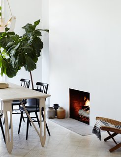 Shaker-style Salt chairs by Tom Kelley join a custom-sized Etoile dining table and Tsuru Flush Mount III pendant, both by Materia Designs. The couple removed an ornamental fireplace mantel in the kitchen, one of few period details they decided not to keep, due to its size.