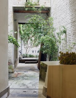 A golden-mirrored Formica piece, presented at Milan Design Week in 2014, punctuates the brick-and-stucco courtyard. 