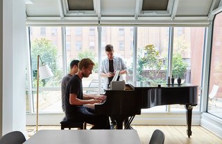 Peter and two of his U.S. colleagues gather around the Steinway piano. 