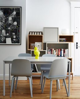 A neon vase by Michael Geertsen contrasts with a gray Base table by Mika Tolvanen and coordinating Nerd and Visu chairs, all for Muuto. 
