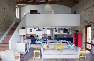 Paired with a lime rendered staircase, a gray Moreau sofa by Pinch and vintage yellow side tables offer bright contrast to the living room’s limestone walls and timber frame. The couple laid some 20,000 pieces of reclaimed oak to create the floor’s herringbone pattern.