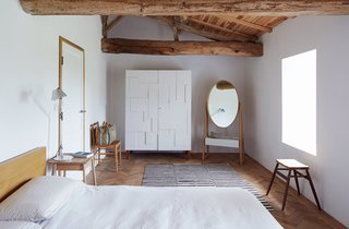 A white Alba armoire by Pinch stands next to the brand’s Iona cheval mirror in a second-floor bedroom. The Moroccan rug was found in Paris; the Malm bed from IKEA was a budget buy.