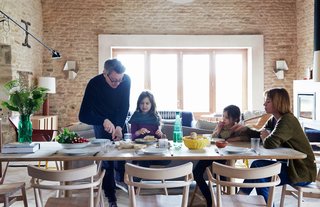 The family gathers at an early prototype of the Achilles table from the Pinch collection. Surrounding it are chairs that were designed by Russell and produced by Ercol for London’s Holland Park School. The couple built the doors and windows themselves.