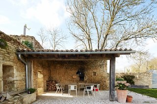 On the terrace, Air chairs by Jasper Morrison for Magis surround an oak table with black trestle legs. The limestone used to build the original structure was sourced from a quarry less than a half-mile away. 