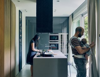 In remodeling a compact Milan apartment, designers Roberto Di Stefano and Alessandro Bongiorni introduced sliding glass doors by Eclisse where a single door once stood to improve connection to the outdoors. In the brightened kitchen, a Comprex cabinet system pairs with Neff appliances. Domenico Mori tiles cover the range hood.