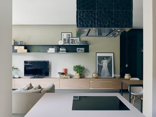 A suspended oak sideboard runs the length of the living room. The project leads designed that piece and the black-painted metal shelves on the wall; both were fabricated by Giuseppe Motta,a local artisan. A 14.1 pendant by Omer Arbel for Bocci hangs near one end.