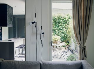 The couple often use the terrace for enjoying an espresso or aperitivo. Parentesi lights by Achille Castiglioni and Pio Manzù for Flos hang next to one of the two entrances to the balcony. 