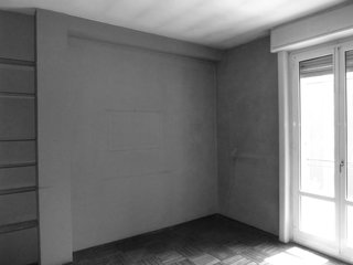 Floor-to-ceiling drapes and doors elongate sightlines, making the room appear more spacious than before. 
