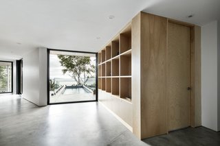 A Home Inspired by the Stars Soars Off the Ground - Photo 2 of 5 - A large window at the end of the corridor on the first floor faces the river and overlooks the pool and deck. The level also includes the children's bedrooms and utilities. 