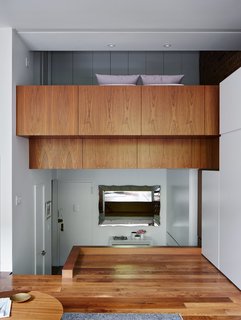The unusual layout of René Roupinian’s Upper West Side home is what initially attracted her to the space, but the three-level plan proved difficult to organize. In his first solo project as STADT Architecture, Christopher Kitterman used a palette of walnut and white to unify the apartment, which he filled with space-saving solutions. Near the entrance, a Goliath table from Resource Furniture can expand to seat up to 10. 