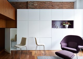 In the living room, laminate cabinets with integrated finger pulls stow René’s belongings, while a purple-accented niche displays favorite objects. 
