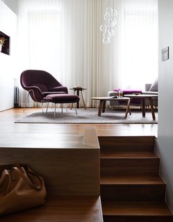 Plum accents, including a Saarinen Womb chair in aubergine Rivington fabric by KnollTextiles, complement the apartment’s exposed brick. The trio of Paper tables, designed by GamFratesi for Gubi, can nest in various formations, while a Clear Ice chandelier from ABC Carpet & Home and semisheer curtains made by Beckenstein Fabric & Interiors lend the room a soft glow.