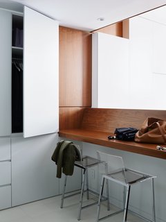 On the first level, a walnut veneer counter offers a place to drop belongings or to enjoy a meal. The walls are painted in Decorator’s White by Benjamin Moore to create a bright but neutral backdrop. Maximizing space was the priority of the remodel. 