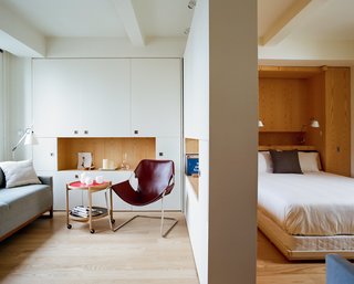 The living area is appointed with small, efficient furnishings, including a rolling tray table by Hans Bolling and a Diplomat Sleeper Sofa by Blu Dot (a second one is situated opposite the Murphy bed).