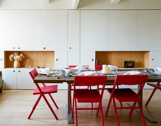 The red Piana folding chairs are by David Chipperfield for Alessi; Garneau custom-designed the millwork tabletop and stainless-steel legs. 