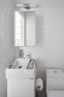 This 390-Square-Foot Renovation Is Compact Yet Comfortable in Greenwich Village - Photo 8 of 9 - In the bathroom, a compact Lillången sink from IKEA offers a narrow profile for the tight space, yet is deep enough to accommodate hanging storage trays for toiletrie. The toilet is by Fresca and the subway tile is from Mosa. 