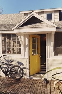 25 Bold Ways to Decorate with Yellow - Photo 21 of 25 - The door to the front porch, painted in Bright Yellow by Benjamin Moore, is inspired by the island’s local flora.