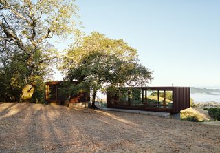 10 Modular Dwellings That Break Away From Traditional Building Practices - Photo 4 of 10 - Both prefab modules are clad in Cor-Ten steel, enabling the main cube to dramatically cantilever out over its foundation.