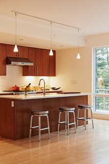 Presented with three possible kitchen units by Blu Homes, the residents selected one that has less cabinetry and a more fluid layout. The bar stools are from Crate and Barrel. 