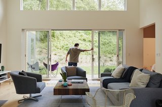 In the living room, a 16-foot-wide sliding glass door opens onto a landscape designed by Rosedale Nurseries. 