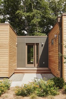 The mudroom is the project’s most customized component. Built on-site, it connects the house with two other Blu Homes prefab designs: an Origin studio, containing the gym/office, and a W-Series garage. James Hardie Reveal siding in Iron Gray distinguishes it from the factory-built modules, which are clad in Western red cedar.
